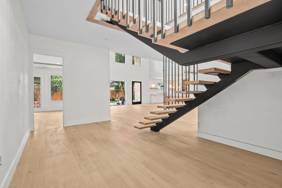 Stepping into the gracious foyer , rich hardwood floors. This gorgeously appointed space with a custom iron stair railing connects to the master bedroom dining and kitchen offering an elegant and welcoming introduction to the home. Setting the tone for the home's exception design and craftsmanship.