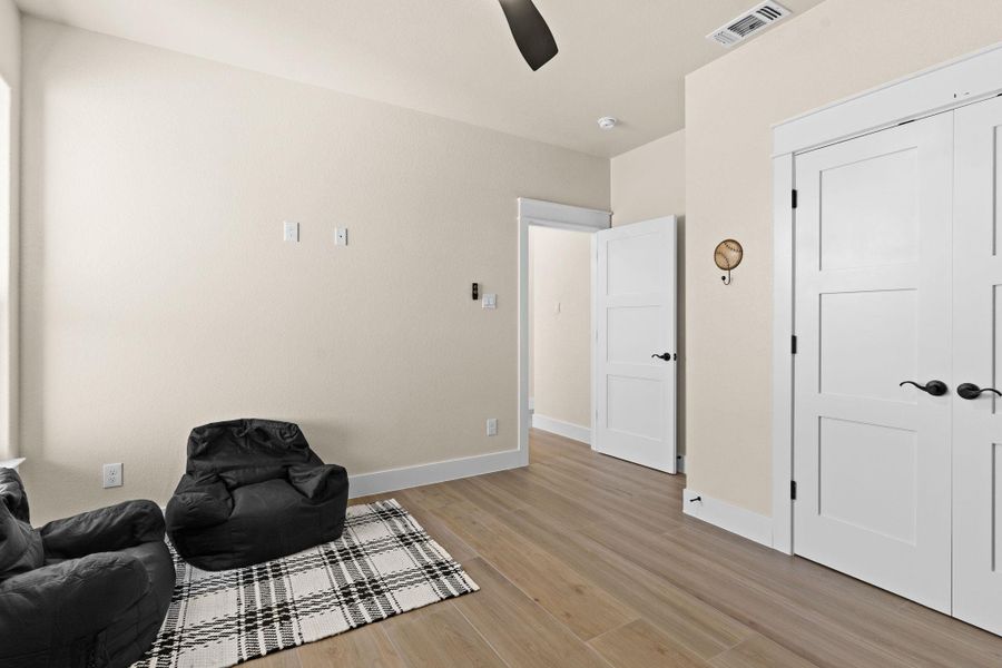 Living area with light wood-style floors, baseboards, and a ceiling fan Living area with light wood-style floors, baseboards, and a ceiling fan