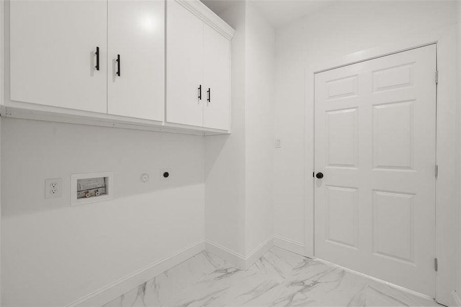 Laundry area featuring cabinet space, hookup for an electric dryer, washer hookup, and light marble finish flooring Laundry area featuring cabinet space, hookup for an electric dryer, washer hookup, and light marble finish flooring