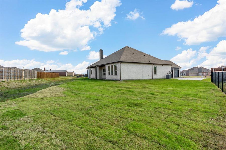 Back of property featuring a lawn