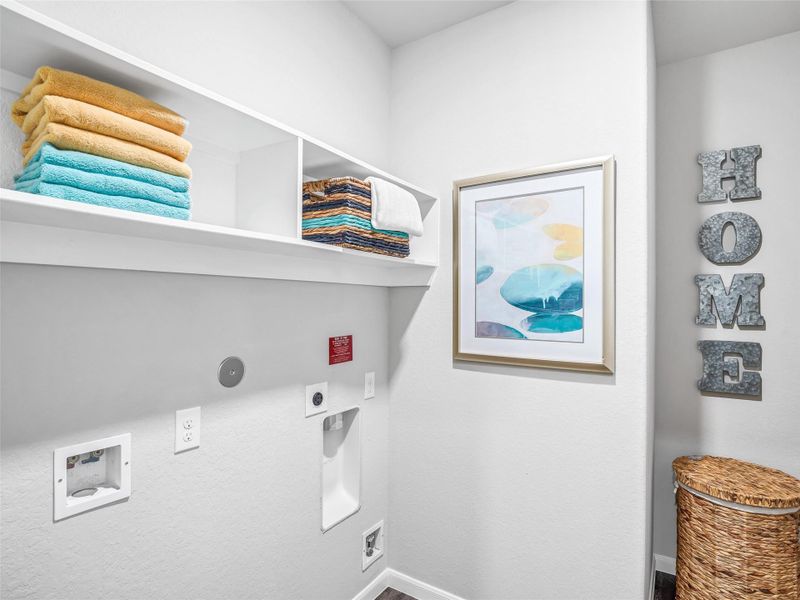 A perfect blend of functionality and comfort. Capture the essence of easy living with a first-floor laundry room, thoughtfully equipped with shelving for effortless organization. Both electric and gas connections available. Sample photo of completed home with similar floor plan. Actual colors and selections may vary. A perfect blend of functionality and comfort. Capture the essence of easy living with a first-floor laundry room, thoughtfully equipped with shelving for effortless organization. Both electric and gas connections available. Sample photo of completed home with similar floor plan. Actual colors and selections may vary.