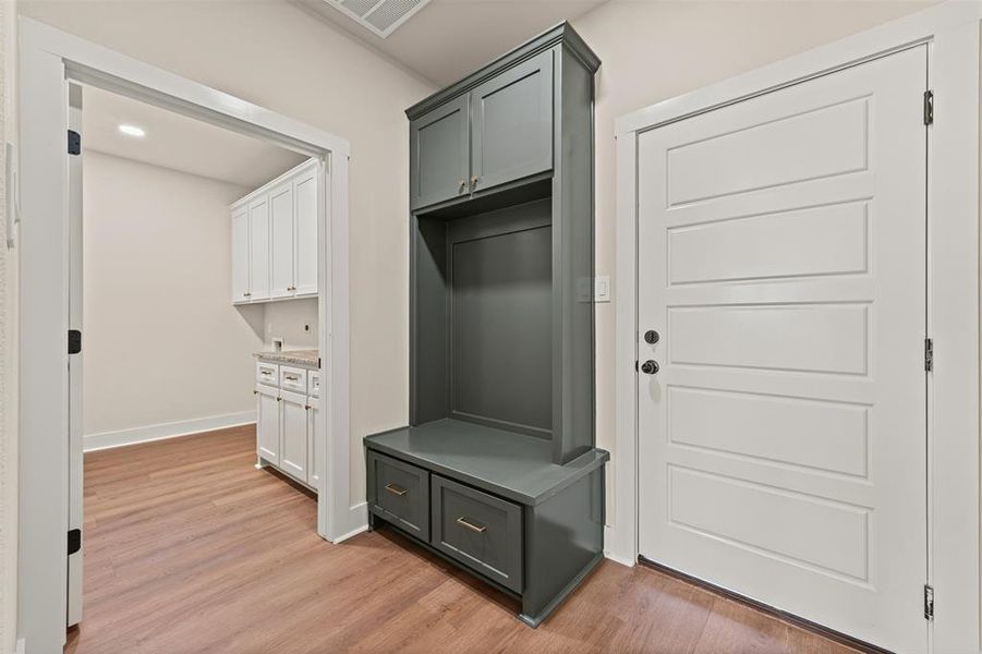 Mudroom with light wood finished floors and recessed lighting