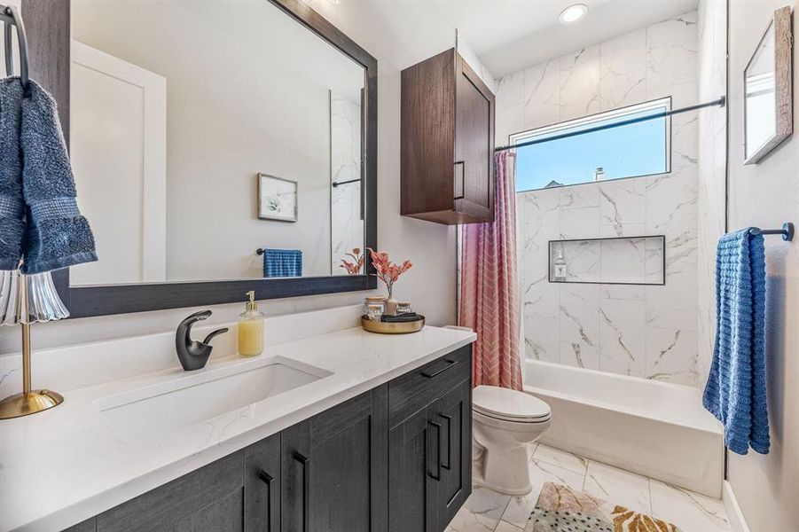 Full bath with vanity, shower / tub combo, and light marble finish floors