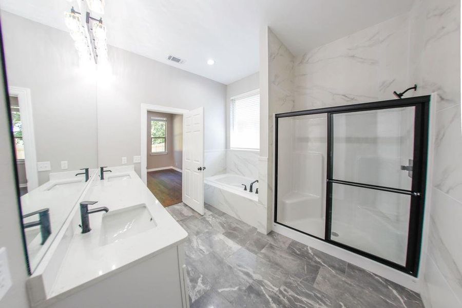 Bathroom with a bath, double vanity, a marble finish shower, dark marble finish flooring, and recessed lighting Bathroom with a bath, double vanity, a marble finish shower, dark marble finish flooring, and recessed lighting