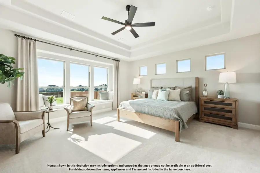 Spacious master bedroom with tray ceiling, ceiling fan, large windows, and neutral carpet Spacious master bedroom with tray ceiling, ceiling fan, large windows, and neutral carpet