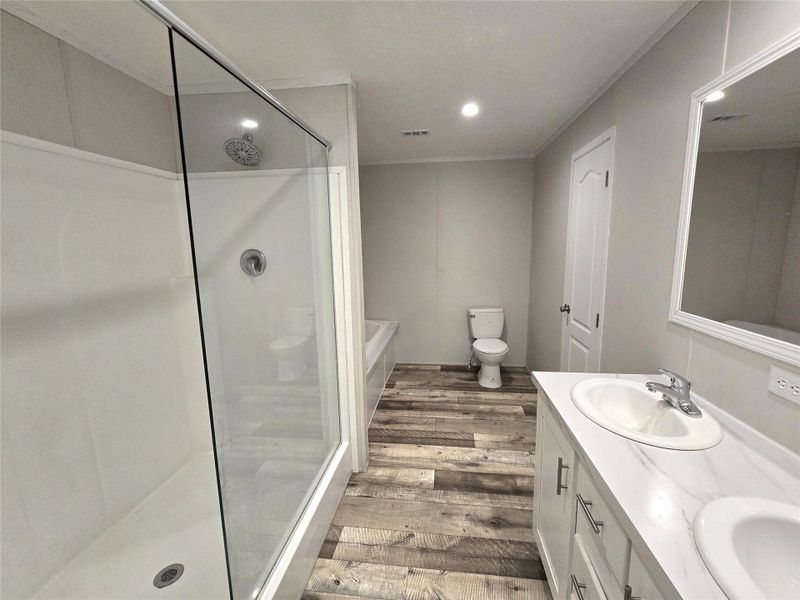 Experience the luxury of this master bath boasting a spacious walk-in shower, dual sinks set in a sleek vanity, and elegant wood-style flooring, creating a serene retreat for relaxation. Experience the luxury of this master bath boasting a spacious walk-in shower, dual sinks set in a sleek vanity, and elegant wood-style flooring, creating a serene retreat for relaxation.