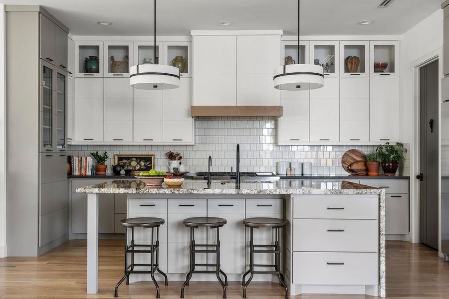 The Chef's Kitchen makes a strong first impression with 10’ cabinetry, two-tone finishes, glass front display cabinets with lighting, and a contemporary ceramic backsplash, all enhanced by under cabinet and recessed lighting.