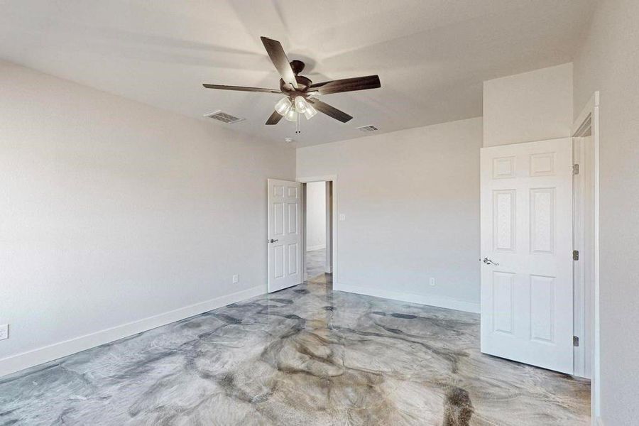 Unfurnished bedroom featuring visible vents, concrete floors, baseboards, and ceiling fan