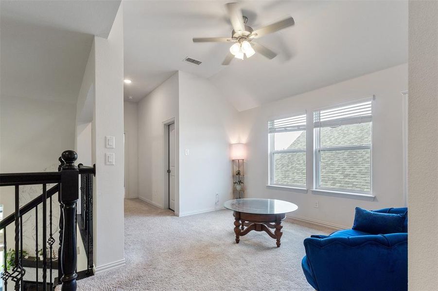 Living area with light carpet, ceiling fan, vaulted ceiling, an upstairs landing, and recessed lighting