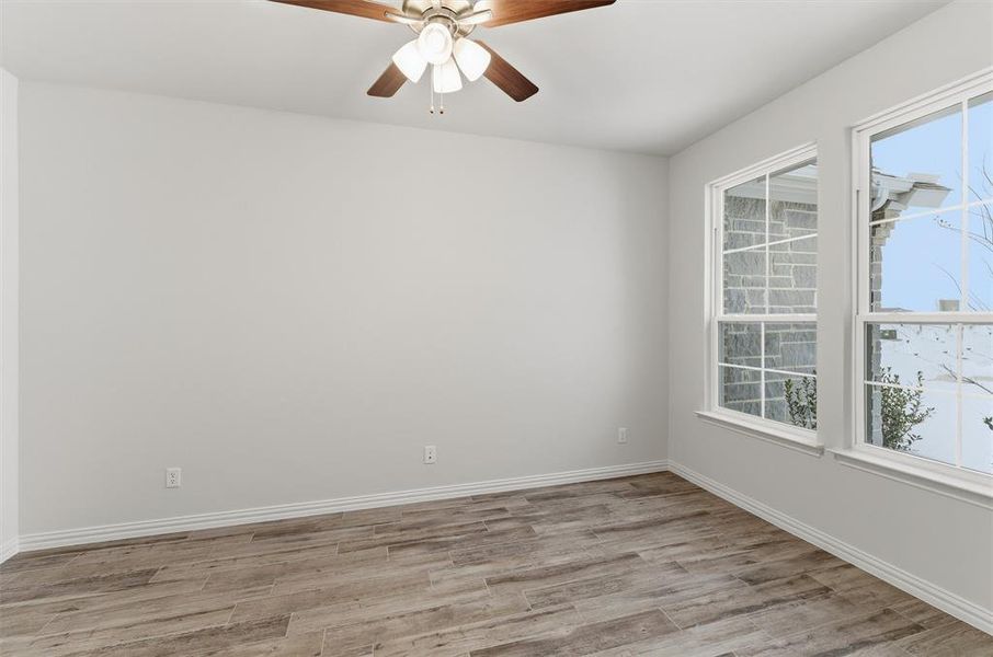 Empty room with light wood finished floors and ceiling fan Empty room with light wood finished floors and ceiling fan