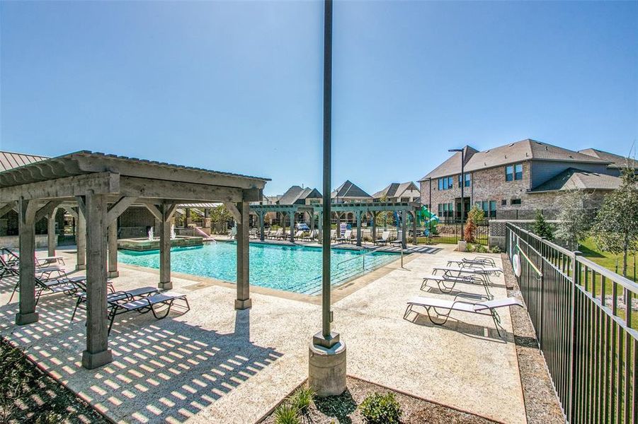 Community pool featuring a patio area and fence