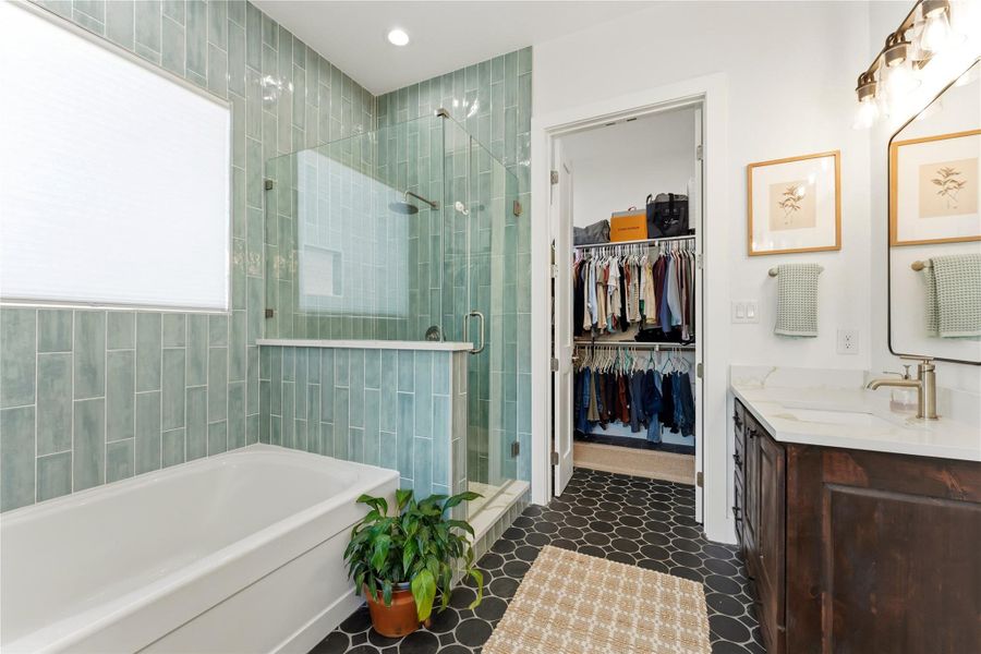 Bathroom with vanity, a stall shower, a garden tub, a walk in closet, and recessed lighting