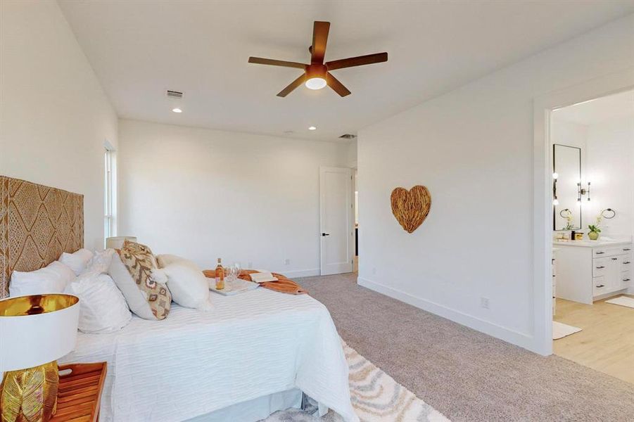 Carpeted bedroom featuring ceiling fan and connected bathroom