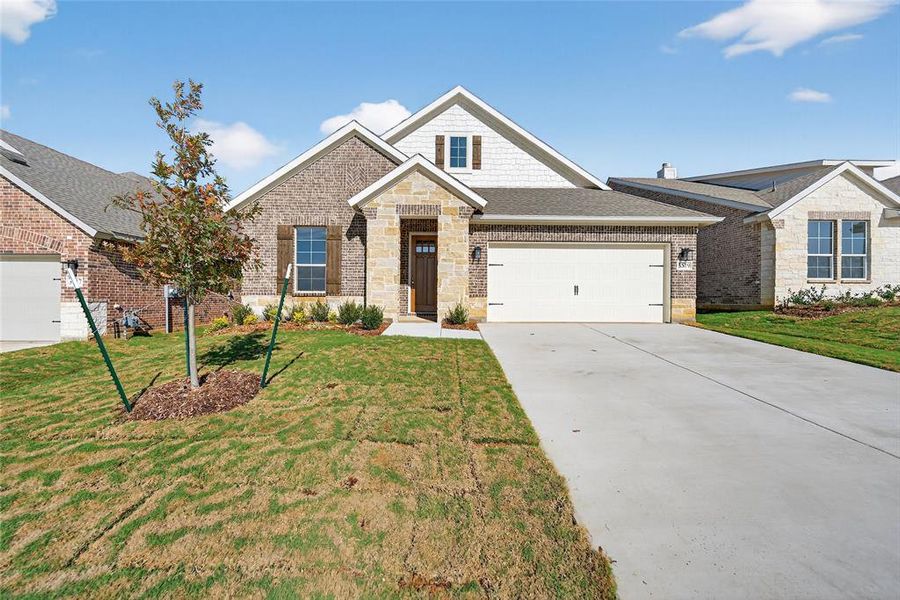 Craftsman house with brick siding, driveway, a front lawn, and a garage