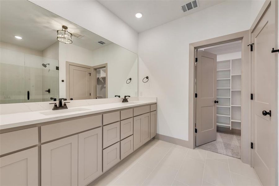 Bathroom with tile patterned flooring, vanity, a notable chandelier, and an enclosed shower