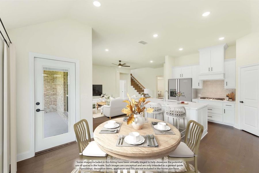 Open-concept dining area with round wood table, white kitchen cabinets, and dark hardwood floors visible from living room Open-concept dining area with round wood table, white kitchen cabinets, and dark hardwood floors visible from living room