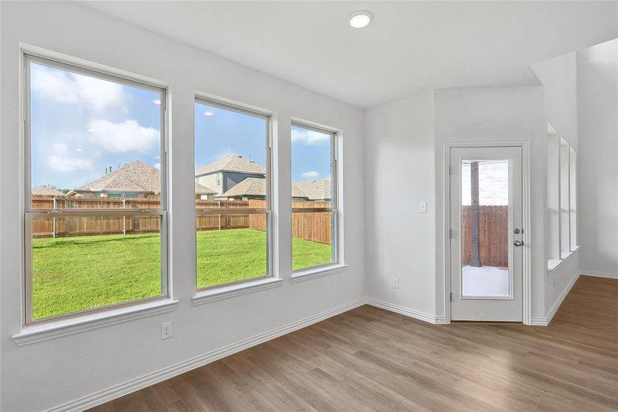 Unfurnished room featuring hardwood / wood-style floors and a wealth of natural light