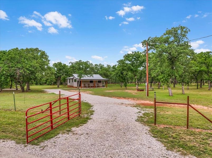 Gravel driveway leading to a residence with a covered porch