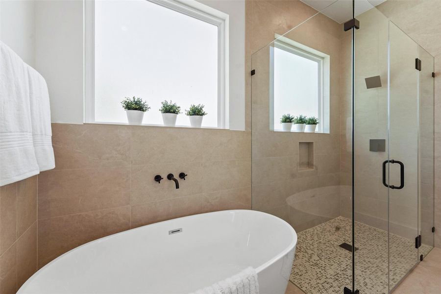 Luxurious primary bathroom with dual sinks, quartz countertops, sleek black fixtures, a frameless glass shower, and abundant natural light. Luxurious primary bathroom with dual sinks, quartz countertops, sleek black fixtures, a frameless glass shower, and abundant natural light.