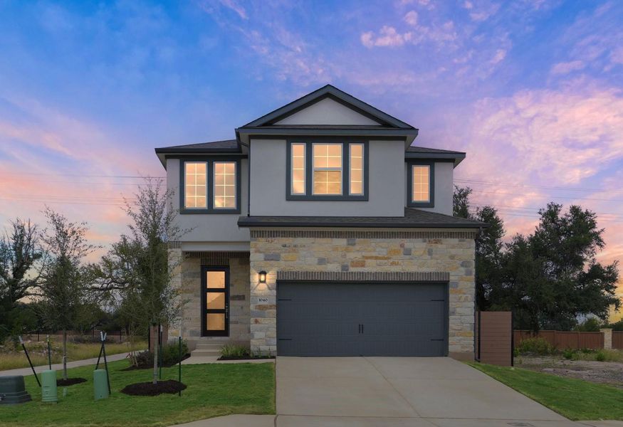 View of front of house with stone siding, stucco siding, a garage, and driveway