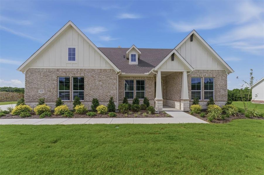 Craftsman-style exterior featuring a light brick facade, white board and batten gables, and an inviting covered entry Craftsman-style exterior featuring a light brick facade, white board and batten gables, and an inviting covered entry