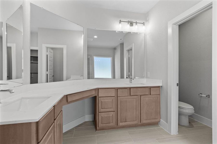 This primary bathroom is definitely move-in ready! Featuring stained cabinets with light countertops, dual vanities, spacious walk-in closet with shelving, high ceilings, custom paint, sleek modern finishes.