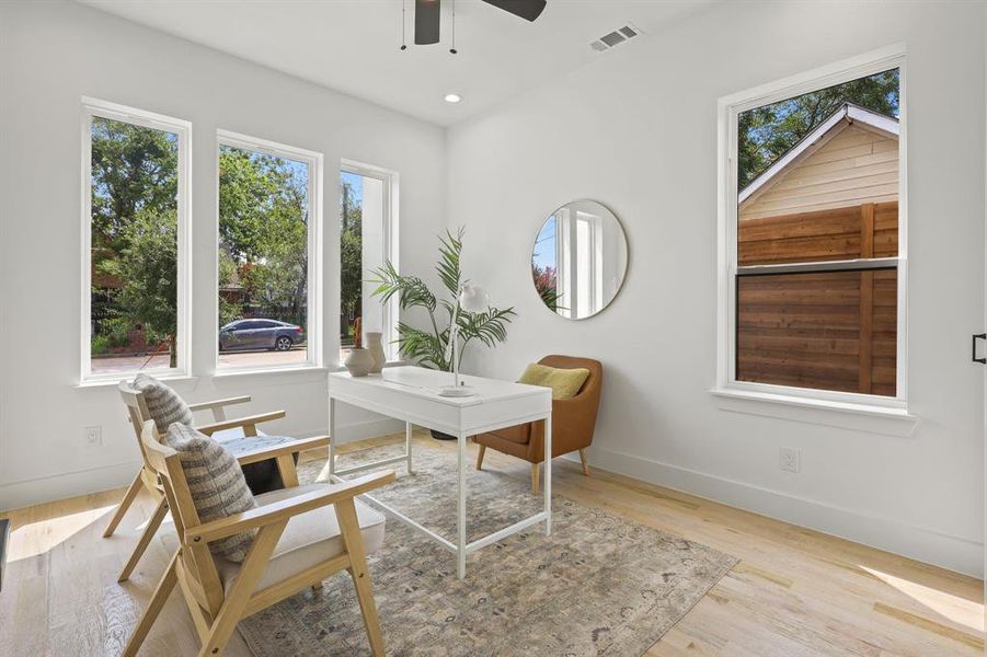 Office area with ceiling fan, light wood-type flooring, and a wealth of natural light