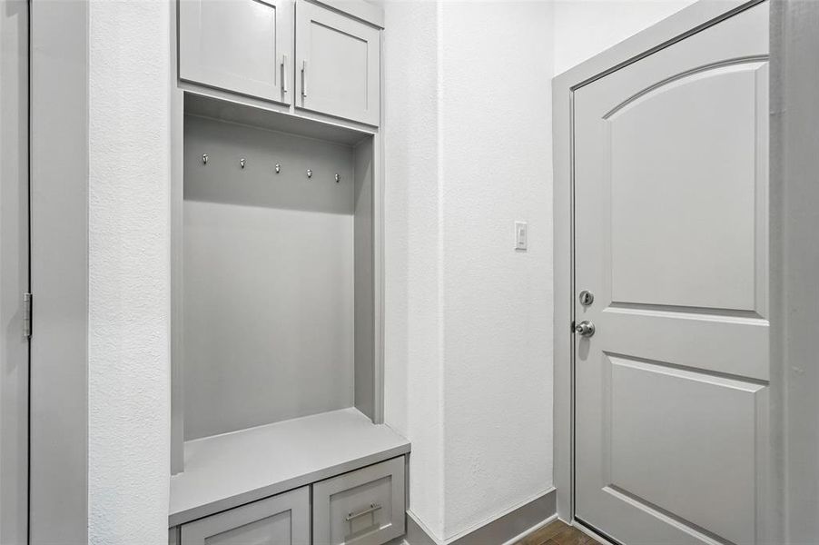 Mudroom featuring dark wood-style floors and a textured wall Mudroom featuring dark wood-style floors and a textured wall