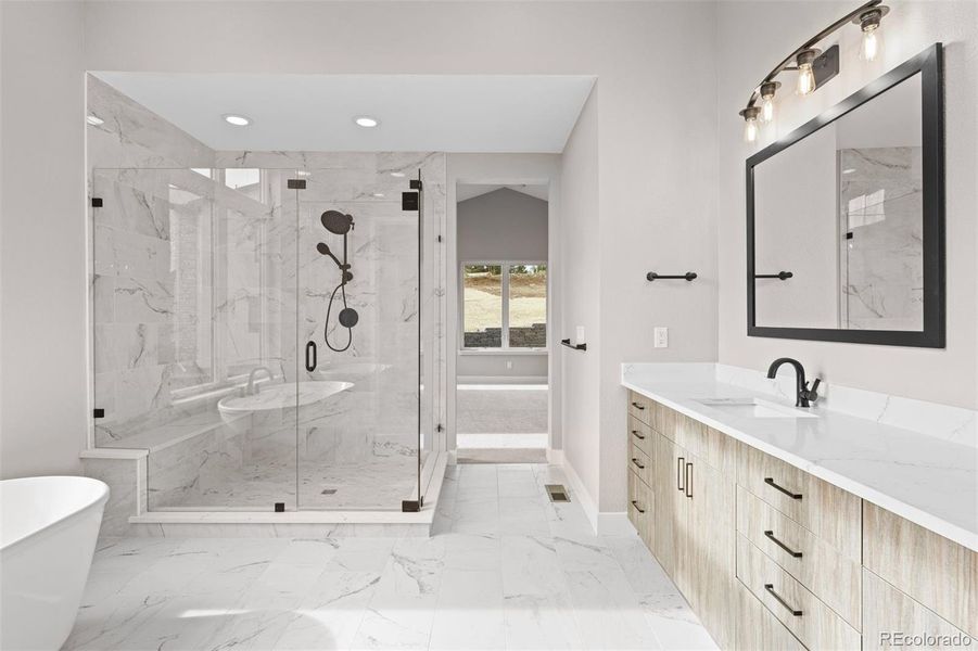 Spa-like primary bathroom with walk-in shower, dual vanity, and luxurious soaking tub.