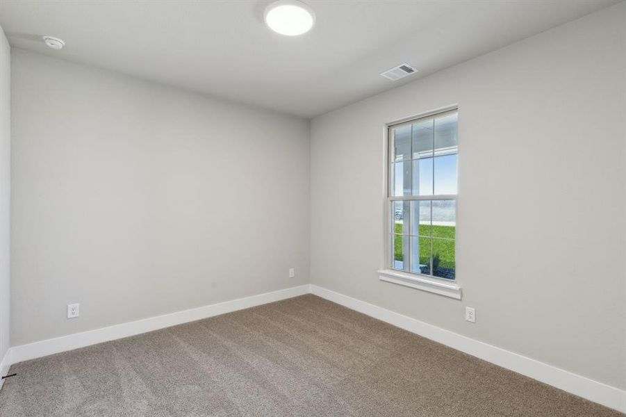 Empty room featuring carpet, visible vents, and baseboards