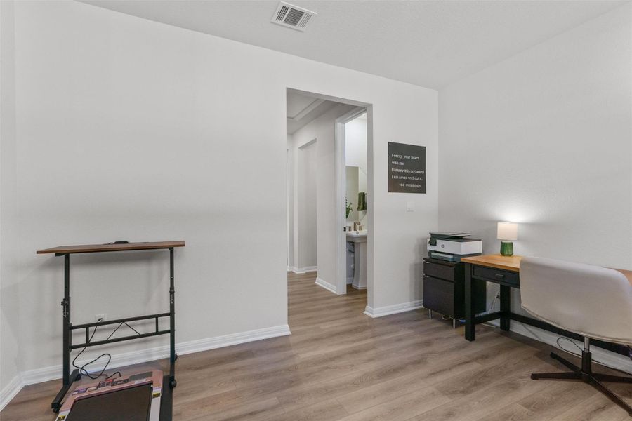 Office with light wood-type flooring and baseboards