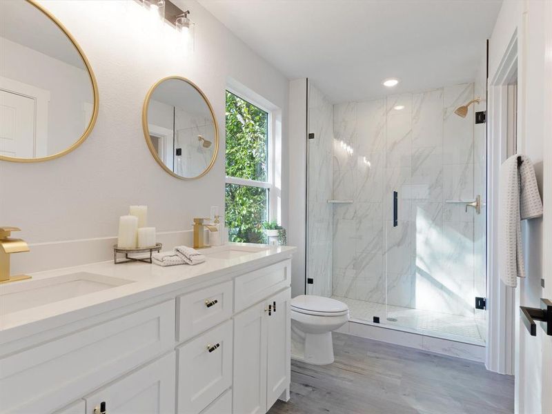 Bathroom with hardwood / wood-style floors, walk in shower, vanity, and toilet