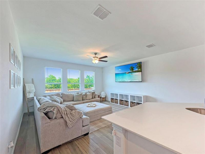 Living area featuring light wood-style floors and a ceiling fan