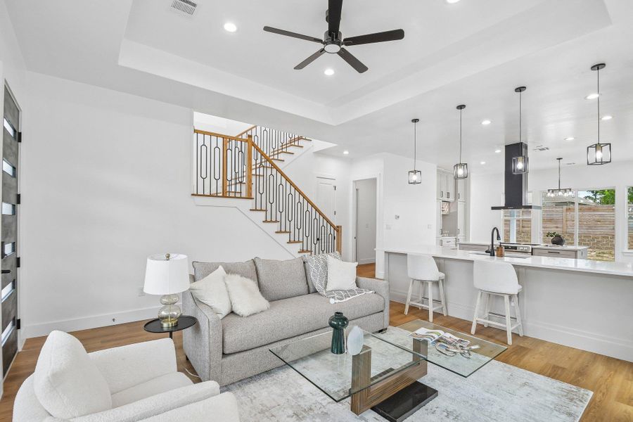An open floor plan connects the living area with a modern kitchen alongside warm hardwood flooring. An open floor plan connects the living area with a modern kitchen alongside warm hardwood flooring.