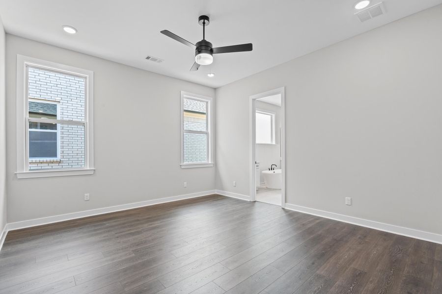 Unfurnished bedroom with dark wood-style flooring, a ceiling fan, recessed lighting, and ensuite bath Unfurnished bedroom with dark wood-style flooring, a ceiling fan, recessed lighting, and ensuite bath