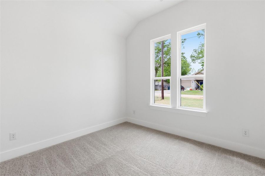 Additional living space featuring light colored carpet and lofted ceiling