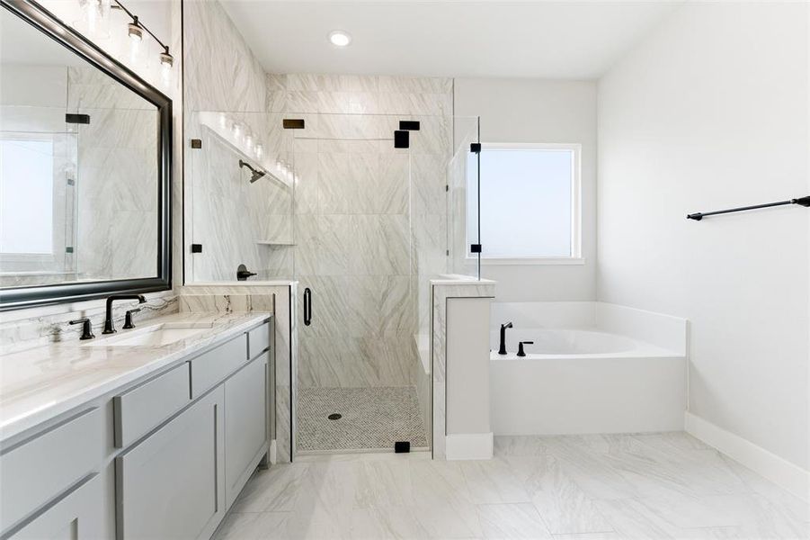 Bathroom featuring a bath, a stall shower, vanity, light marble finish floors, and recessed lighting