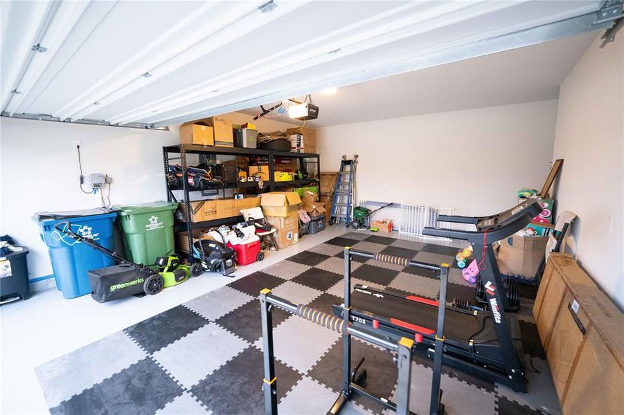 Interior garage with high ceilings, white walls, and a checkerboard floor Interior garage with high ceilings, white walls, and a checkerboard floor