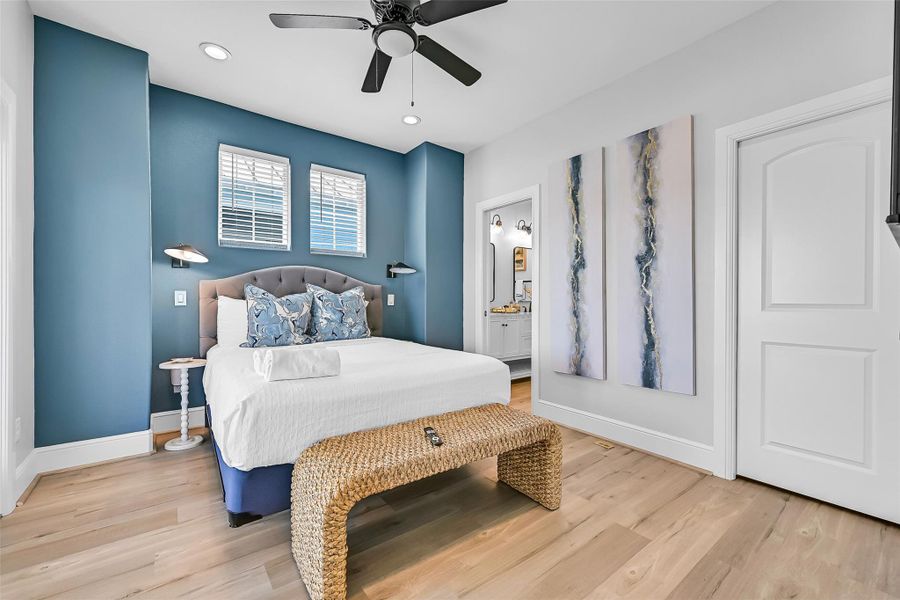 The second primary bedroom upstairs  includes soft coastal palette and natural light create a bedroom retreat buyers can instantly picture themselves enjoying every day.  Notice the ensuite to the right, and to the left is a door to the beautiful deck with ocean views!