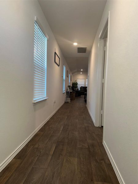 Hallway featuring dark wood finished floors and baseboards
