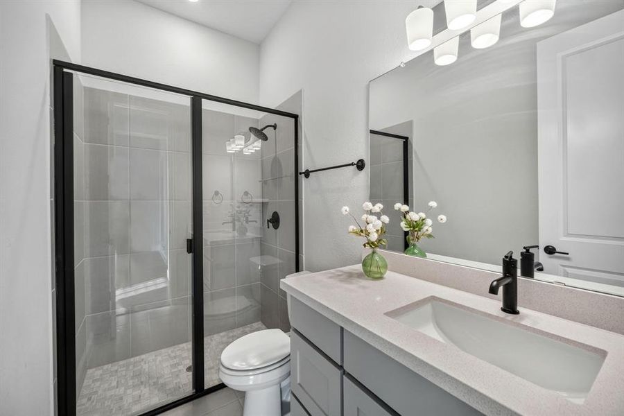 First floor modern bathroom featuring a walk-in shower with black-framed glass enclosure, light-toned wall tiling, and a patterned floor