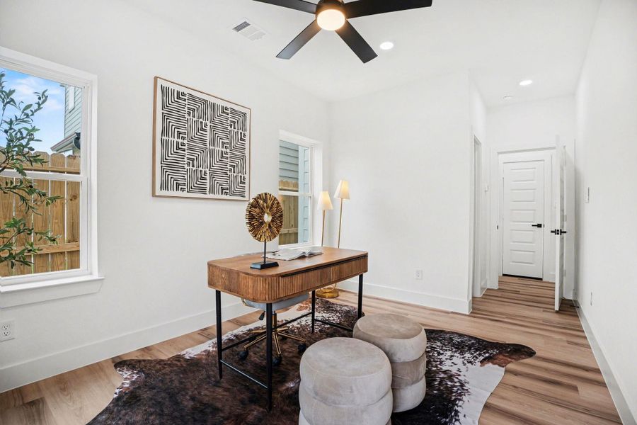 This bright, modern home office (or secondary bedroom) features large windows, a glass door for natural light, and a full walk-in close, and bathroom.