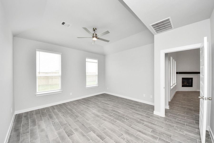 Come and unwind after a long day in this magnificent primary suite! This spacious room features warm paint, high ceilings and large windows with privacy blinds. Sample photo of completed home with similar floor plan. Actual colors and selections may vary.