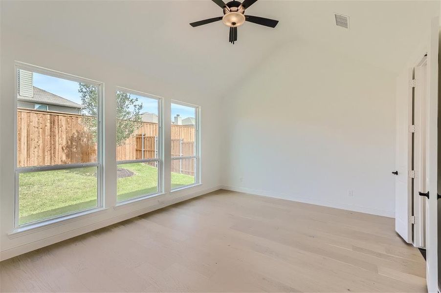 Spare room featuring high vaulted ceiling, light wood-type flooring, and ceiling fan