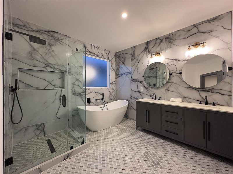 Bathroom featuring shower with separate bathtub, double sink vanity, tile walls, and tile patterned flooring