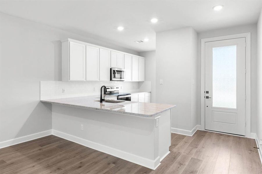 Kitchen featuring new Whirlpool appliances, 42" cabinets, and LVP flooring.