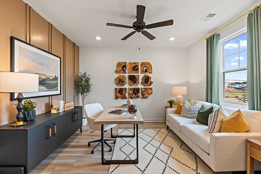 A living room with a fan and a couch. A living room with a fan and a couch.