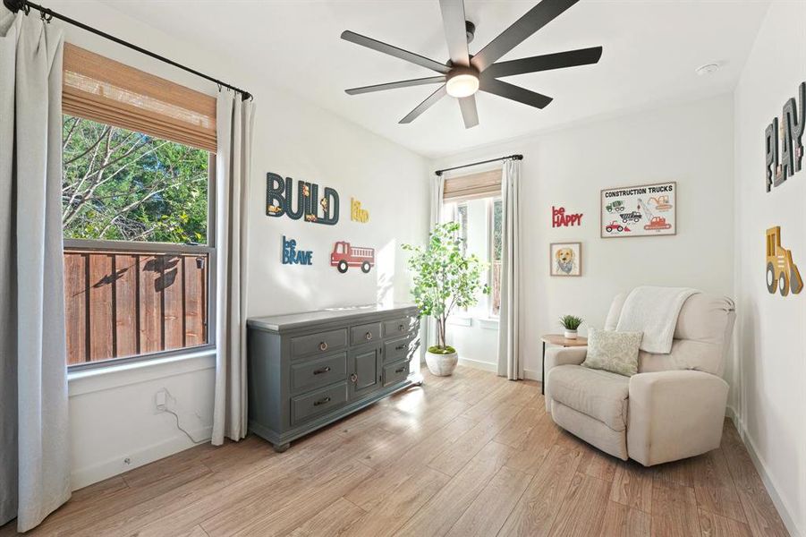Living area featuring light wood finished floors and a ceiling fan