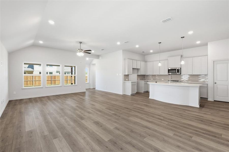 Unfurnished living room featuring a ceiling fan, recessed lighting, light wood finished floors, and lofted ceiling