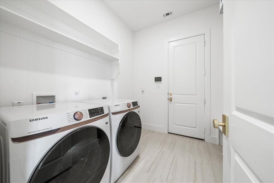 Laundry area with laundry area, visible vents, baseboards, and separate washer and dryer